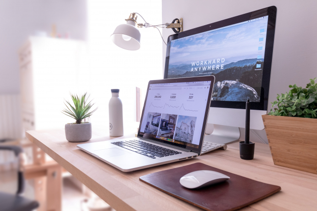 A neat workstation has a computer with a background that says "work hard anywhere"