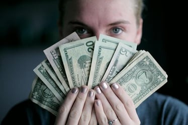 A highly paid woman holding a lot of bank notes.