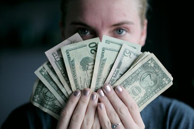 A highly paid woman holding a lot of bank notes.