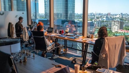A modern office space with a floor to ceiling window.