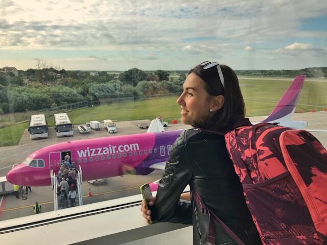 A young adult at an airport waiting for their flight as they move abroad.