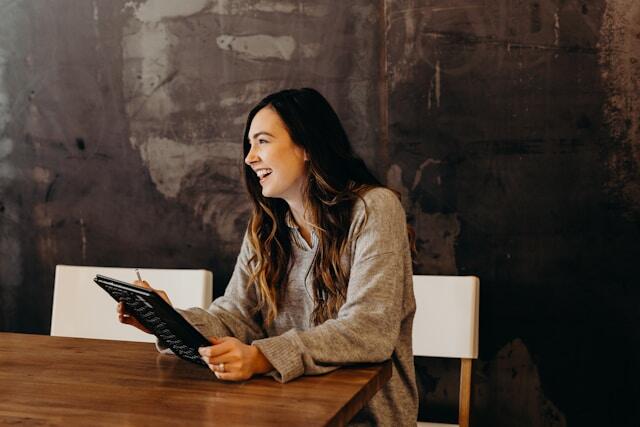 A young professional laughing as she works during her internship abroad.