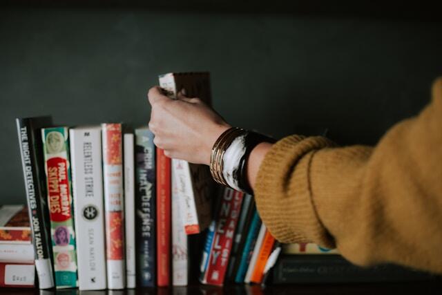 A person browsing a bookshelf.
