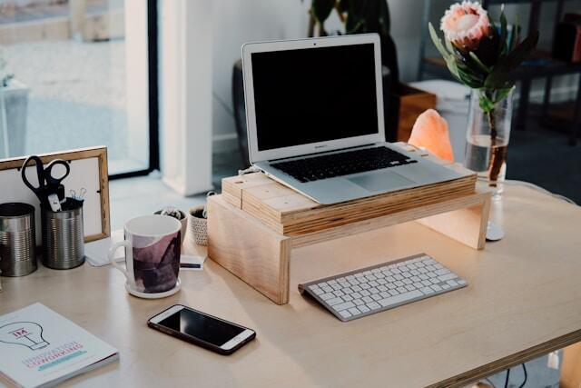 A clean home office desk featuring a laptop and a cup of coffee.