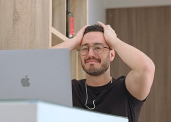 A young professional puts his hands on his head after making a mistake at work