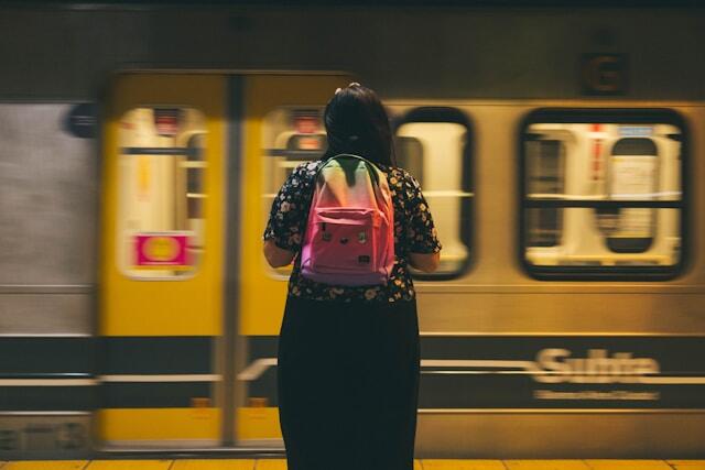 A woman traveling alone prepares to board a train.