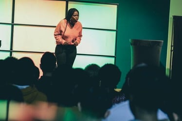 A young professional using her public speaking skills to give a presentation at her internship abroad.