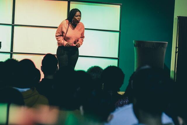 A young professional using her public speaking skills to give a presentation at her internship abroad.