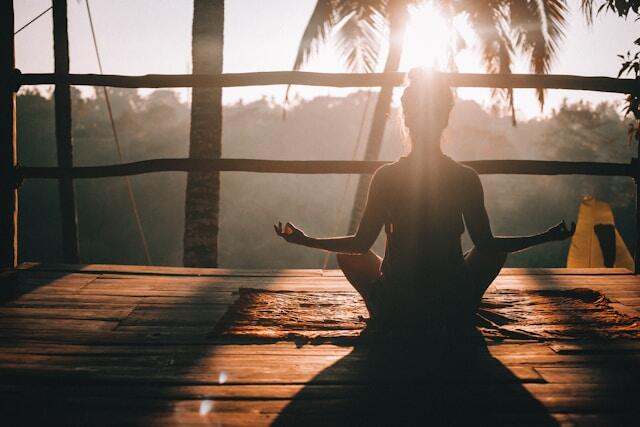 A young professional meditates in the early morning before work during her internship abroad.