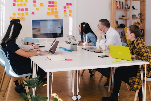Interns abroad working together around a table in a relaxed office.