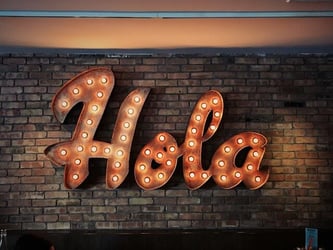 A sign in Spanish that reads 'Hola'