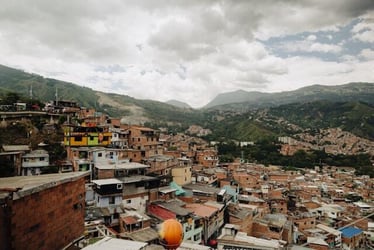 A view of colorful buildings in Medellín with hills and mountains in the background.