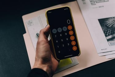 An intern using a calculator while organizing their funding for an internship abroad.