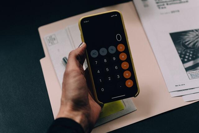 An intern using a calculator while organizing their funding for an internship abroad.