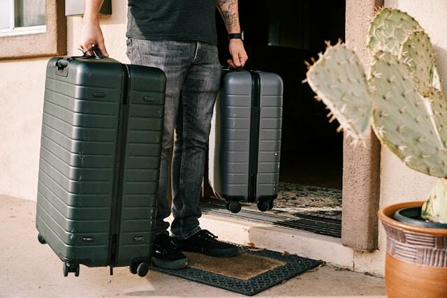 A young professional carrying two suitcases.