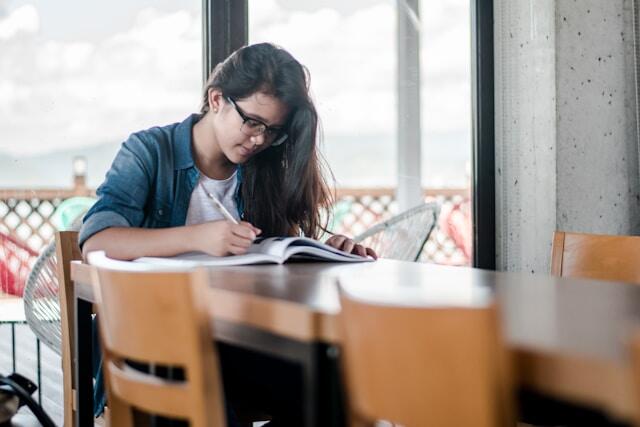 A young professional making notes about a company before her job interview.
