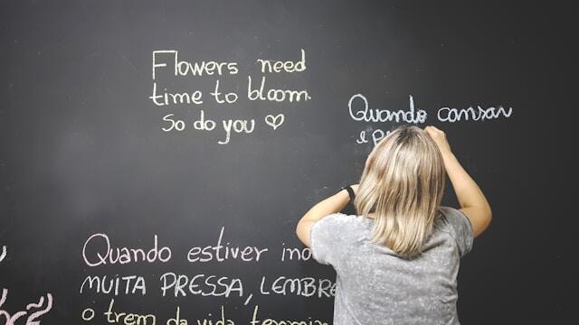 A professional learning a new language by writing sentences on a blackboard.
