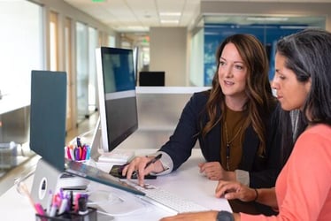 An middle-aged woman getting training from her manager during an internship abroad.