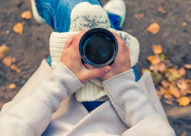 A person taking a break during their fall internship with a cup of coffee.