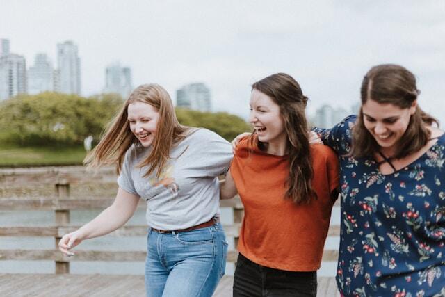 Three friends laugh together during their internship abroad