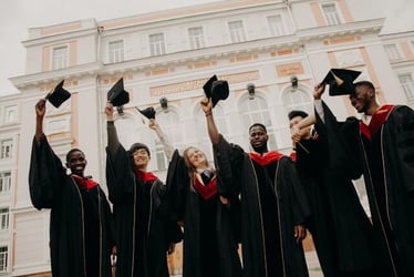 Graduates in their graduation robes celebrating.