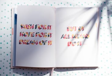 A notebook that says 'Wish for it. Hope for it. Dream of it. But by all means do it...'
