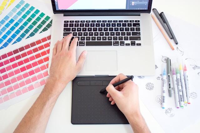 Completing a task at a graphic design internship with a laptop and tablet.
