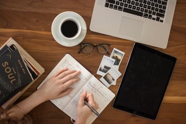 A professional makes notes in a notebook for their journalism internship.