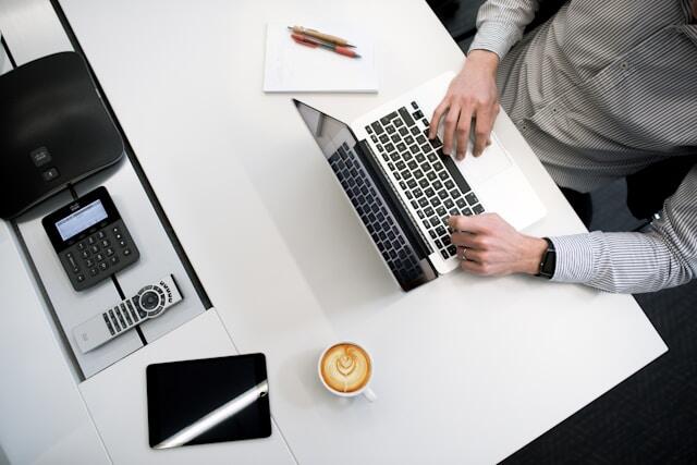 A business major doing a business internship abroad, working with a laptop and notebook.