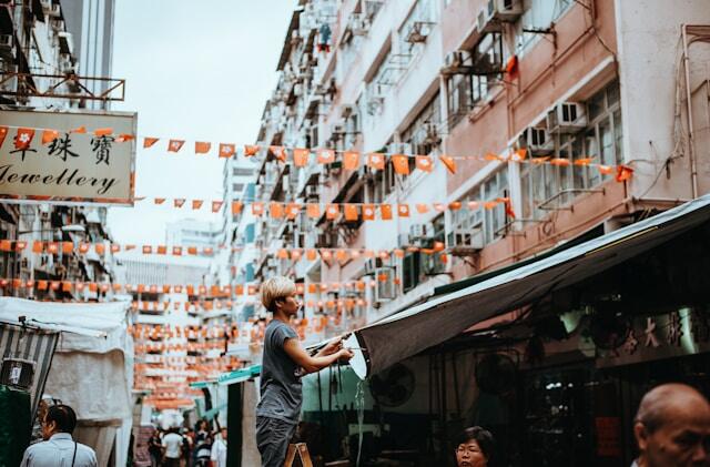 A street in Hong Kong, Between the buildings are strings of bunting with the Hong Kong flag.