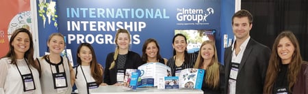 David Lloyd, second from the right, with other members of The Intern Group team, standing in front of a branded background and showcasing TIG branded materials
