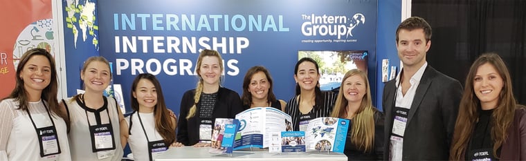 David Lloyd, second from the right, with other members of The Intern Group team, standing in front of a branded background and showcasing TIG branded materials
