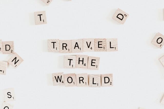 A selection of Scrabble tiles laid out to read 'travel the world'