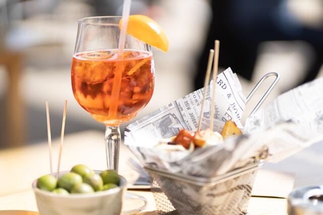 A close up view of olives and a glass of wine at a Spanish restaurant.