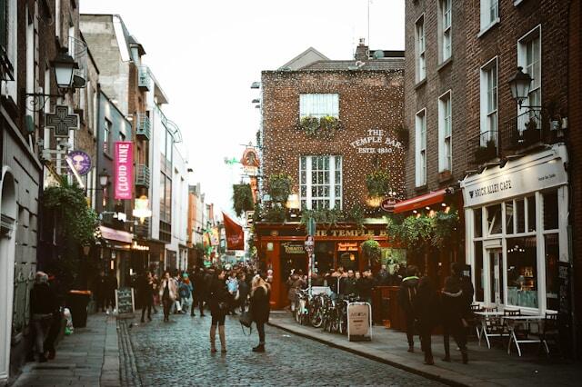 A cobbled street in Dublin surrounded by brick buildings. In the middle distance is The Temple Bar pub.