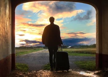 A young professional arriving with a suitcase for his internship abroad.