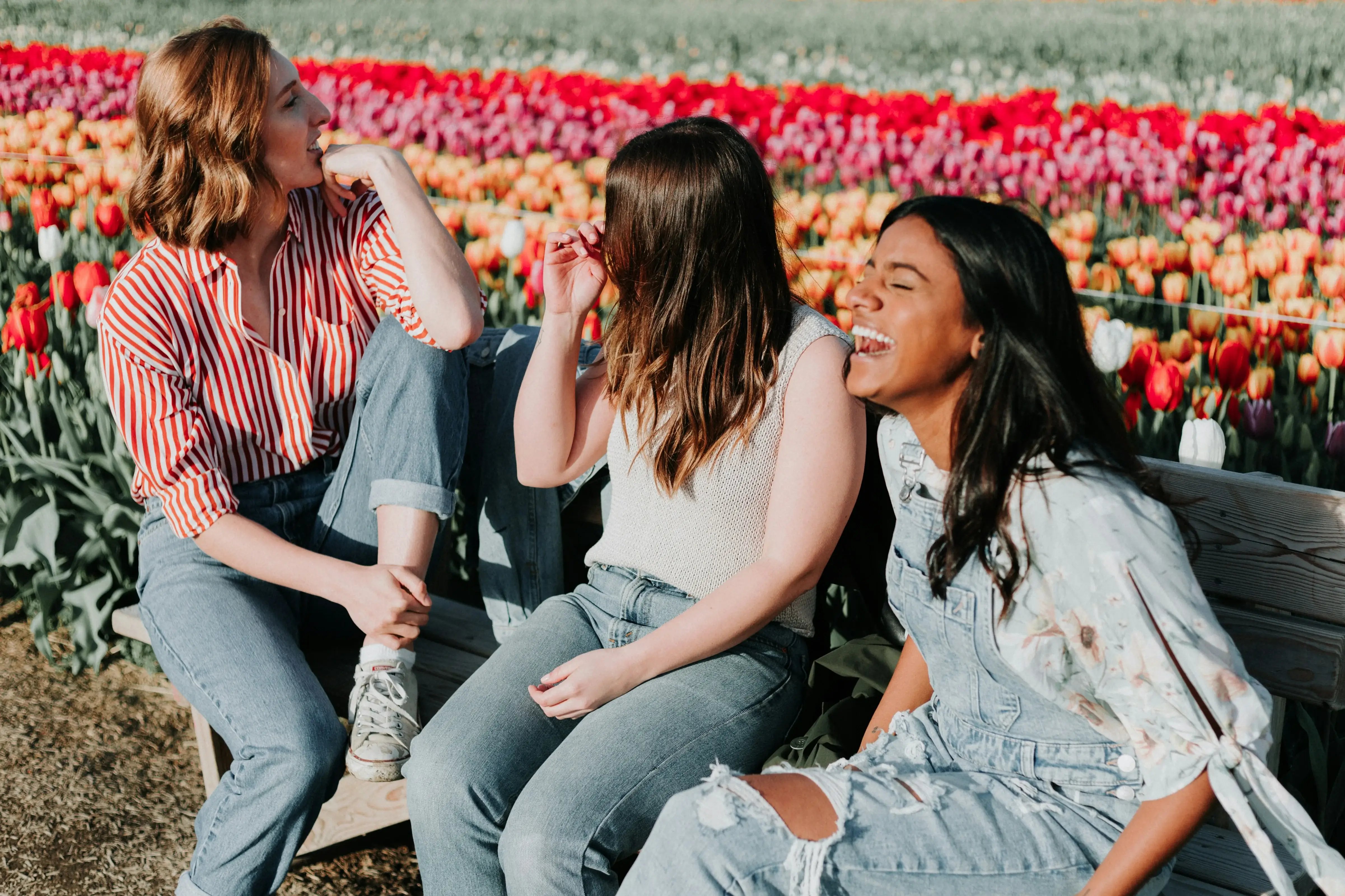 Group of female friends laughing in a day trip to a tulip field